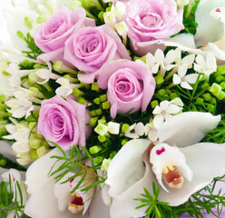 Bouquet of pink roses and white orchids creating delicate floral arrangement