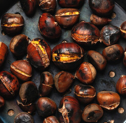 Roasted chestnuts lying on dark surface