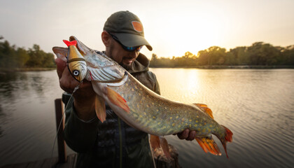 Fisherman and trophy Pike. Fishing background.