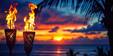 Hawaii luau party Maui fire tiki torches with open flames burning at sunset sky clouds at night