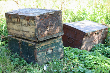 Three old wood chests closed outdoor in garden.