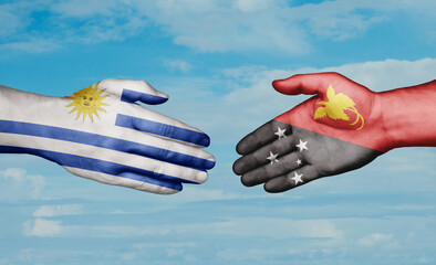Papua New Guinea and Uruguay country handshaking with flags, consensus concept international...