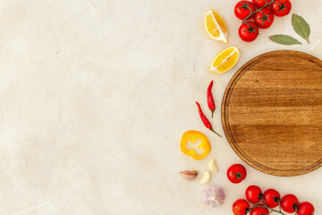 Wooden cutting board and vegetables with spices, top view. Cooking layout