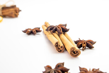 Cut orange and different spices  on white background. Traditional festive winter beverage.Cinnamon, dried orange, anise and cloves