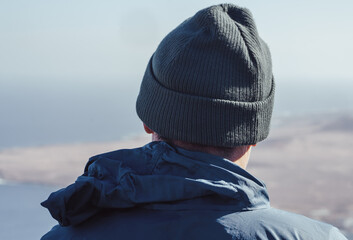 A man in a hat is looking on a beautiful landscape with ocean. © Zhanna