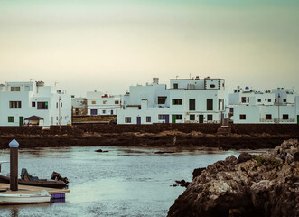 Yachts, boats in a bay of the Atlantic Ocean, a beautiful town with white houses on the background.