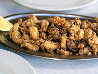 A plate with fried small delicious cuttlefish, grilled seafood closeup.