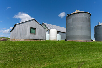 Some farm metal building and water tanks on a blue sky