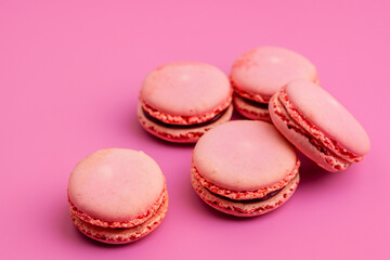 Fototapeta premium White and pink macaroons with pink and white . macaroon dessert concept. a plate of macaroons and sweets in pink on a . a white and pink macaroons with sweets on a lifestyle.