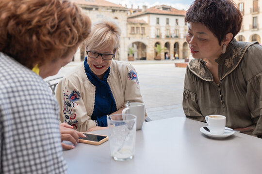 Mature women chatting in a town square over coffee