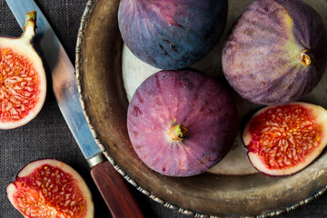 Fresh figs on a dark background, whole and sliced ripe, delicious and sweet figs with a kitchen...