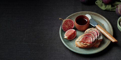 Close-up view of sandwich with fresh fig slices, cream cheese spread and honey on white bread. Healthy eating. Vegetarian breakfast, lunch or snack