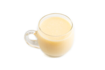 Organic non dairy banana and soy milk in glass isolated on white, side view, close up.
