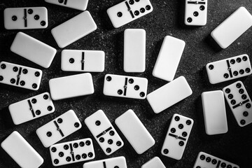 Scatter of vintage dominoes on a dark surface