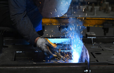 Welding worker working in the factory, welding and joining metals together