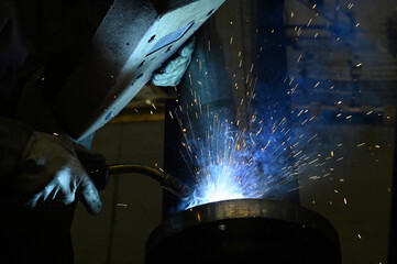 Welding worker working in the factory, welding and joining metals together