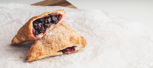 bun with cherry jam on wooden desk