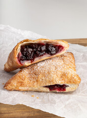 bun with cherry jam on wooden desk