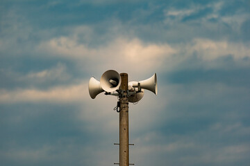 荒々しい雲の空と防災スピーカー