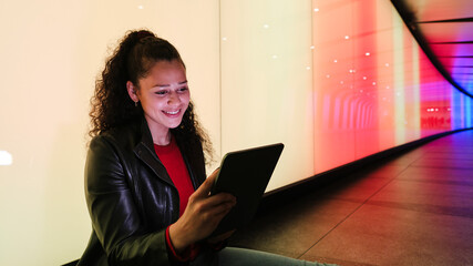 Young woman using tablet in colorful tunnel