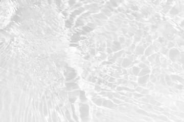 White water with ripples on the surface. Defocus blurred transparent white colored clear calm water surface texture with splashes and bubbles. Water waves with shining pattern texture background.