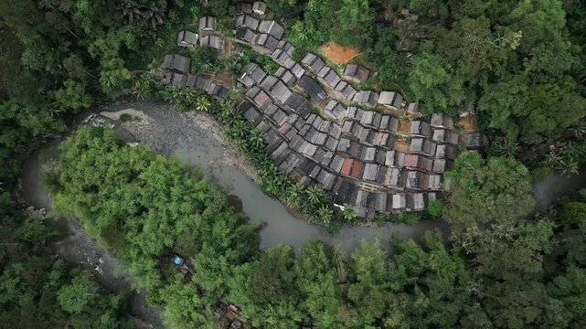 Drone view the traditional houses of the Baduy Tribe are neatly arranged amidst the green forest and flowing rivers, located in Kanekes Village, in the interior of Lebak Regency, Banten, Indonesia.