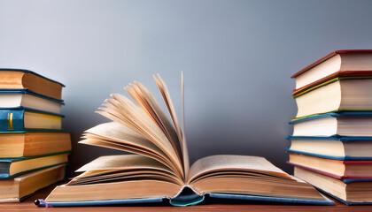 A book is open on a shelf next to a stack of books