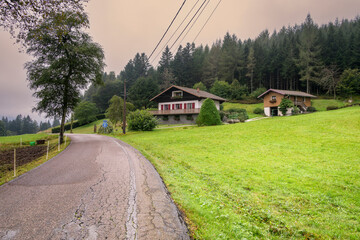 Fototapeta premium Chalet de montagne au bord d'une petite route de montagne dans les Vosges