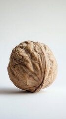 Single walnut resting on white background