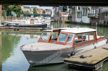 Obraz premium Small wooden boat docked in a peaceful canal surrounded by historic buildings.