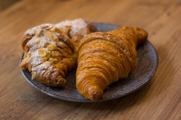 close-up of croissants stacked on wooden table.