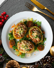 Baked potatoes stuffed with meat and baked in the oven. Top view table with Christmas decorations.