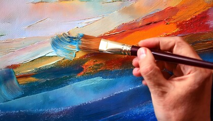 Obraz premium close-up captures an artist's hand skillfully holding a paintbrush as it glides across a canvas