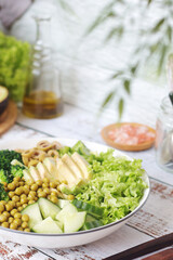 A bowl with a salad made of green vegetables	