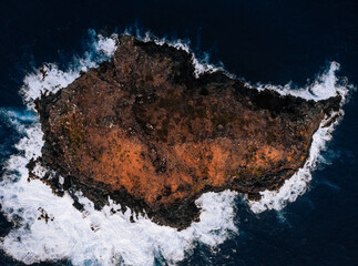 Aerial (top) view of small island (rock) looks like Australia with waves and cliffs by the atlantic ocean - Spain, Tenerife (Garachico)