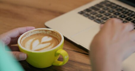 Young business woman having a delicious cup of coffee and working with laptop and phone in a city center cafe, well-deserved break between tasks, working remotely, online store, entrepreneur