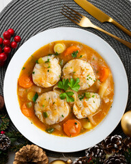 Stewed hake medallions with vegetables. Top view table with Christmas decorations.