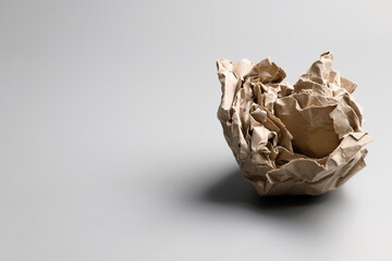A crumpled paper ball on gray background, symbolic object of mistake, fail, and unsuccess idea,...