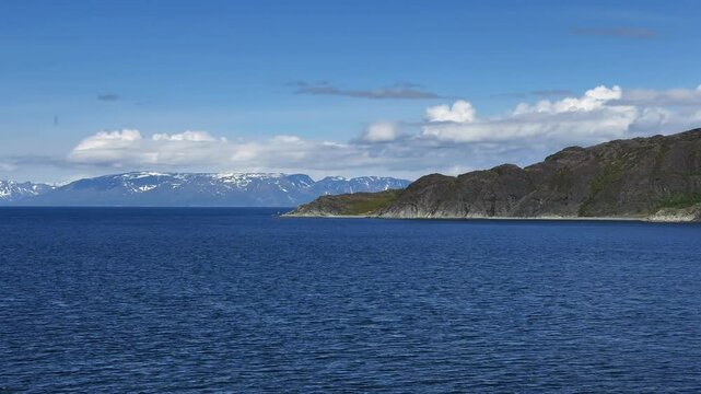 Altenesbukta, Kravelvika, Kviby, Alta Municipality, Finnmark, Norway - slowly cruising past the many bays at a sunny day while leaving the fjord by boat