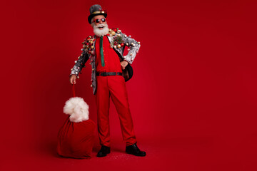 Full size photo of cheerful old man look empty space gift sack wear christmas tree balls costume...