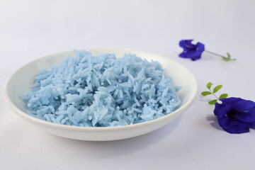 Purple steamed rice in a cream-colored plate Place the dark purple butterfly pea flowers on the side of the plate on a white surface.

ไอคอนยืนยันโดยชุมชน