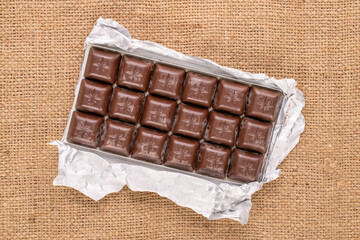Dark chocolate on a jute cloth, macro, top view.