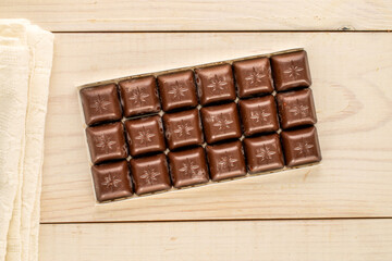 Dark chocolate on wooden table, macro, top view.