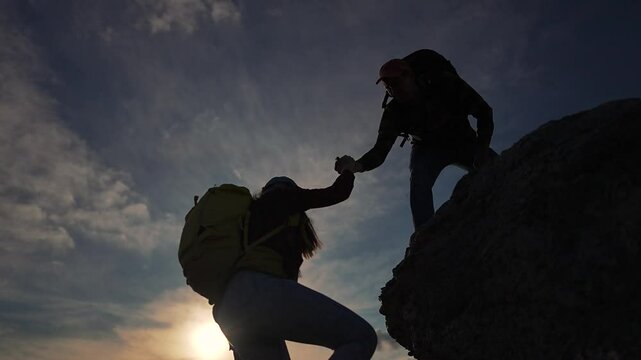Man helps woman climb mountain. Family travel adventure showcasing teamwork success. Family support highlights help overcoming challenges. Success travel through family help. Team spirit help nature.