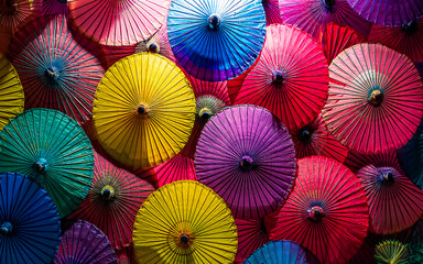 Naklejka premium Colorful asian paper umbrellas from above, AI generated