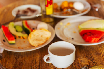 A dining table with plates of delicious food and steaming coffee