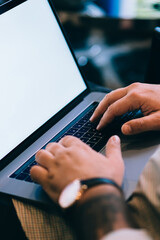 Close up view of male hands on keyboard of laptop computer, cropped view with soft focus of internet user using technology for online communication. Online banking operations, mock up blank screen