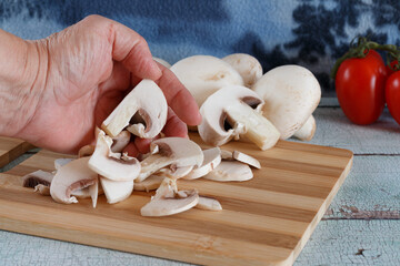 slicing fresh mushrooms on cutting board
