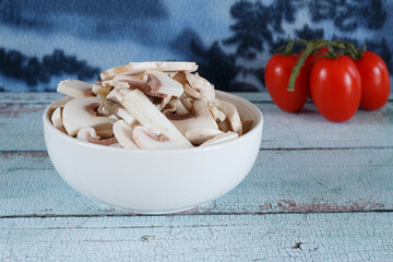 fresh white mushrooms in a white bowl close up 