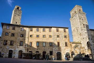 Fototapeta premium san gimignano, italien - 07.02.2024 - piazza della cisterna mit altem brunnen und geschlechtertürmen